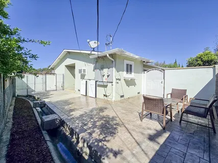a view of a house with backyard and sitting area