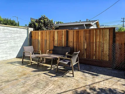 a view of a chairs with barbeque grill and wooden fence