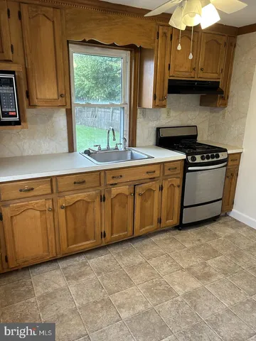 a kitchen with stainless steel appliances granite countertop a sink and a stove