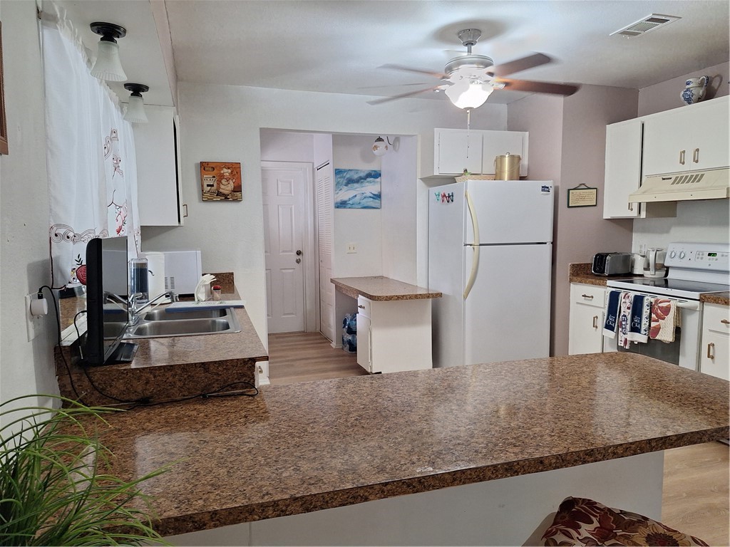 999 Laredo Lane Sebastian, FL 32958 - Photo 10 of 19 a kitchen with refrigerator and white cabinets