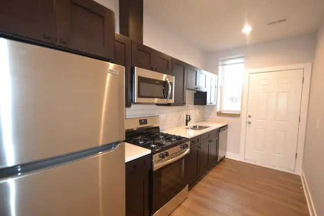a kitchen with stainless steel appliances a refrigerator stove and microwave