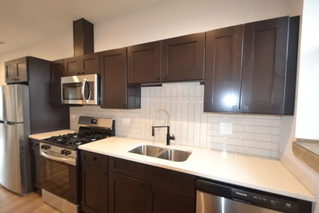 a kitchen with a sink cabinets and stainless steel appliances