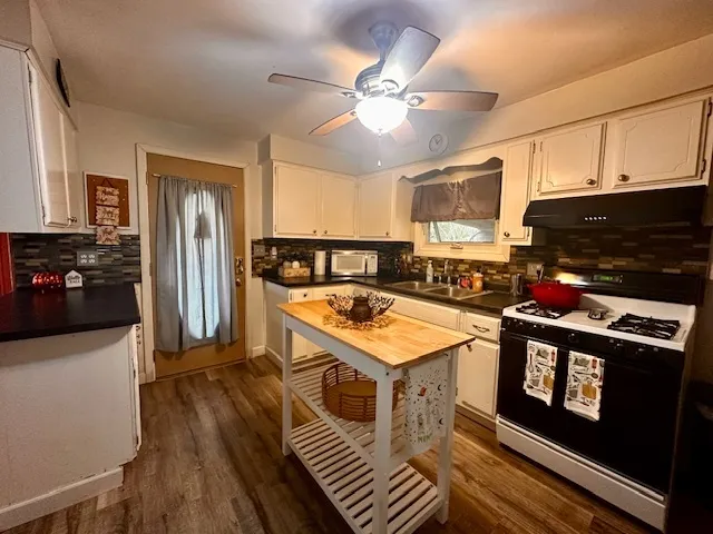 a kitchen with a stove a refrigerator and a microwave