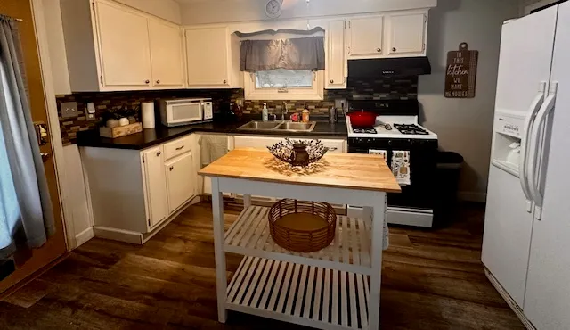 a kitchen with stainless steel appliances granite countertop a stove a refrigerator and a cabinets