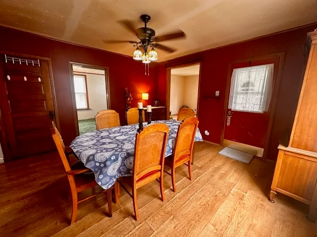 a dining room with furniture a chandelier and wooden floor