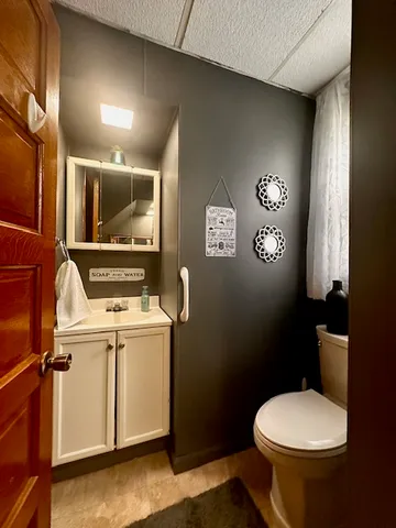 a bathroom with a toilet sink and mirror