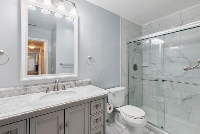 a bathroom with a granite countertop sink toilet and shower