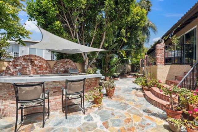a view of patio with table and chairs and potted plants