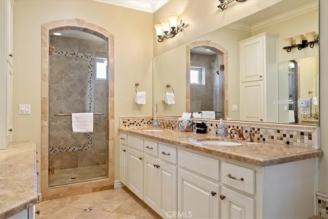 a bathroom with a double vanity sink mirror and shower