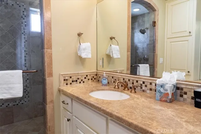 a bathroom with a granite countertop sink and a mirror