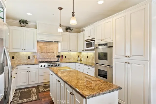 a kitchen with stainless steel appliances granite countertop a sink stove and refrigerator