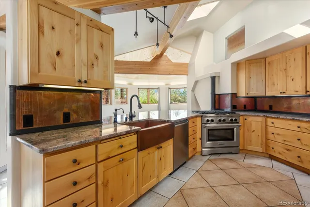 a kitchen with stainless steel appliances granite countertop a sink stove and cabinets