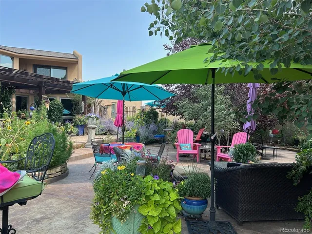 a view of a chairs and table under an umbrella in the patio