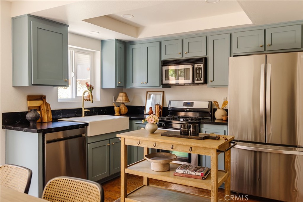 a kitchen with stainless steel appliances granite countertop a refrigerator stove microwave and sink