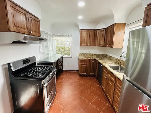 a kitchen with stainless steel appliances a sink stove and cabinets