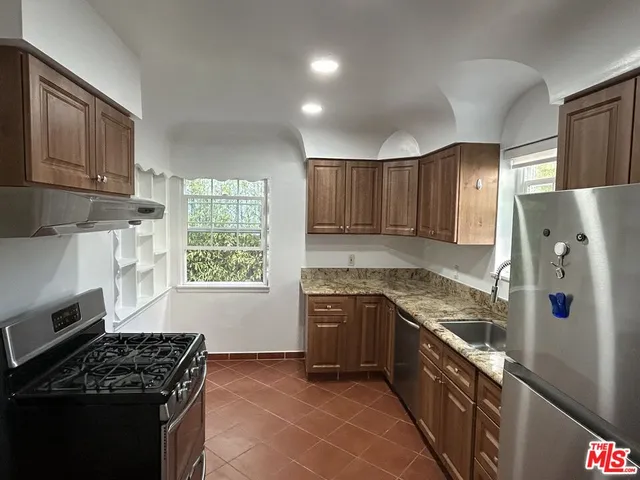a kitchen with stainless steel appliances granite countertop a stove a sink dishwasher a refrigerator and a microwave