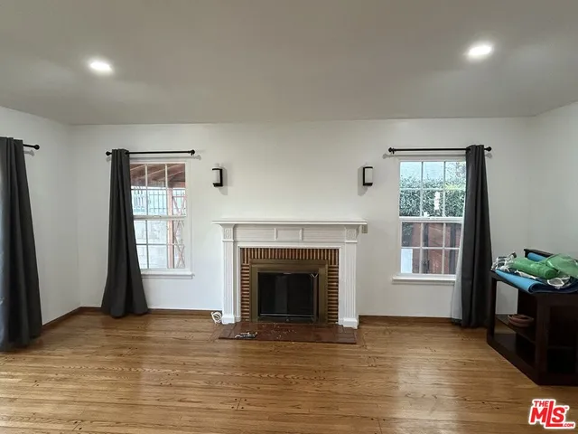 a view of an empty room with a window and fireplace