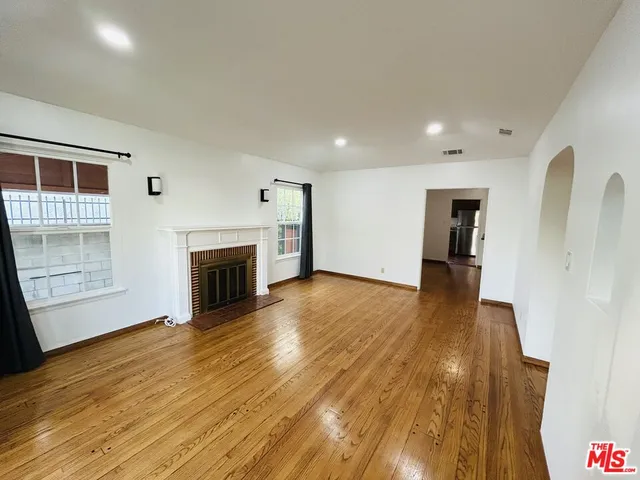 a view of a livingroom with wooden floor and a fireplace