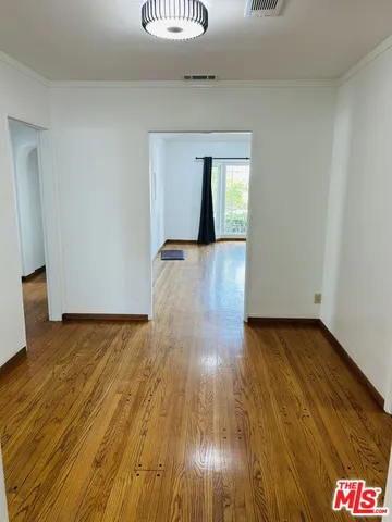 a view of empty room with wooden floor