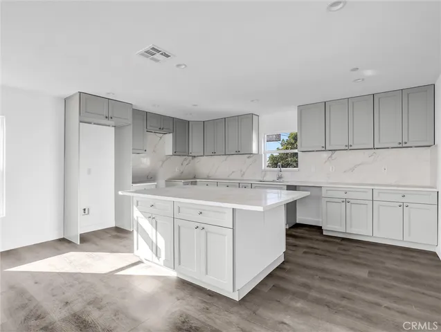 a kitchen with granite countertop a sink and cabinets
