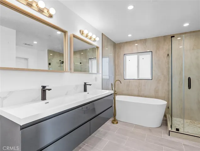a bathroom with a tub a sink and a mirror