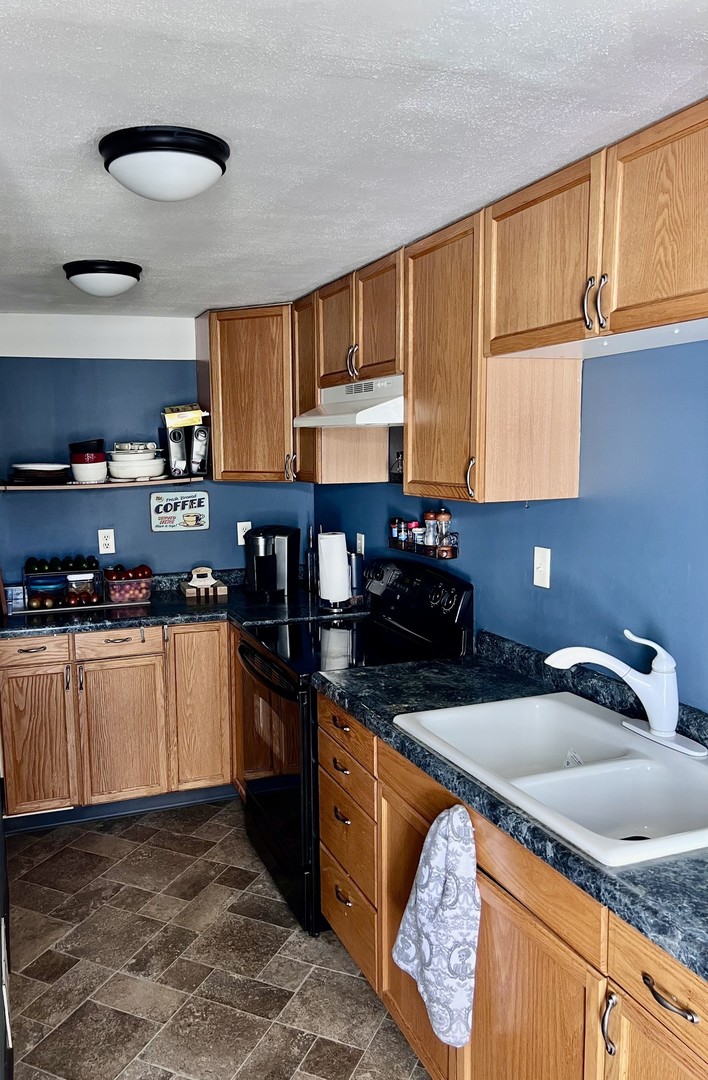 1410 3rd Avenue Sterling, IL 61081 - Photo 5 of 13 a kitchen with granite countertop a sink a stove and cabinets