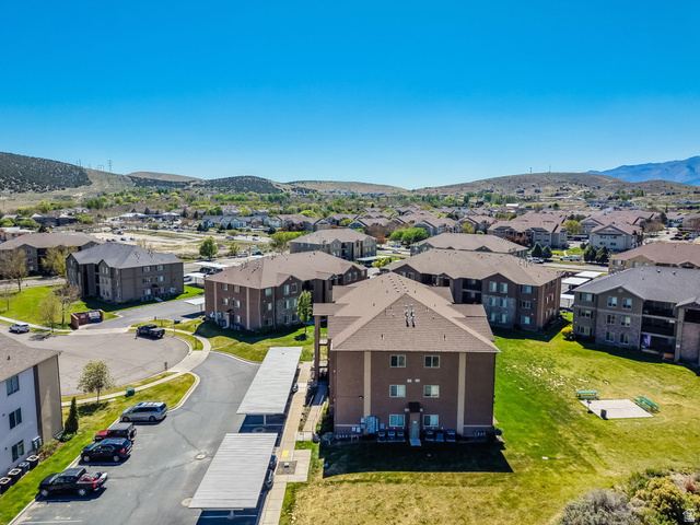8215 Clear Rock Road, Unit 12 Eagle Mountain, UT 84005 - Photo 18 of 38 Multi-story apartment building with a brown facade, featuring individual balconies and a pitched roof