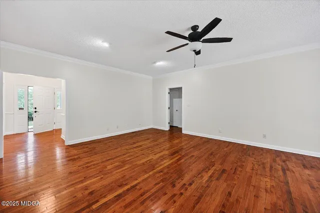 a view of empty room with wooden floor