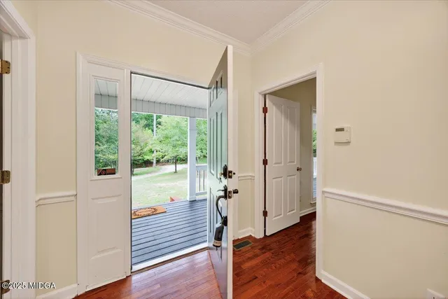 a view of a hallway with wooden floor and stairs