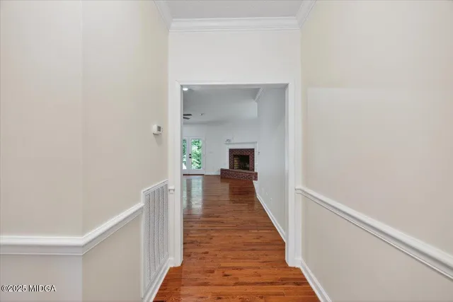 a view of a hallway with wooden floor and a living room