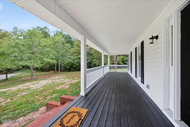 a view of backyard with large trees and wooden fence