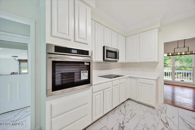 a kitchen with granite countertop white cabinets and appliances