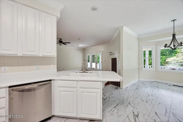 a kitchen with white cabinets and sink