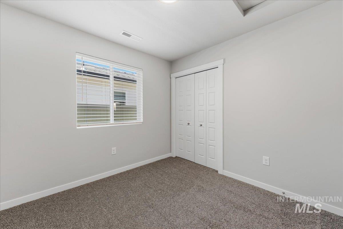 3091 S Green Boise, ID 83709 - Photo 15 of 27 Neutral wall finishes, textured carpeting, and a bi-fold closet door