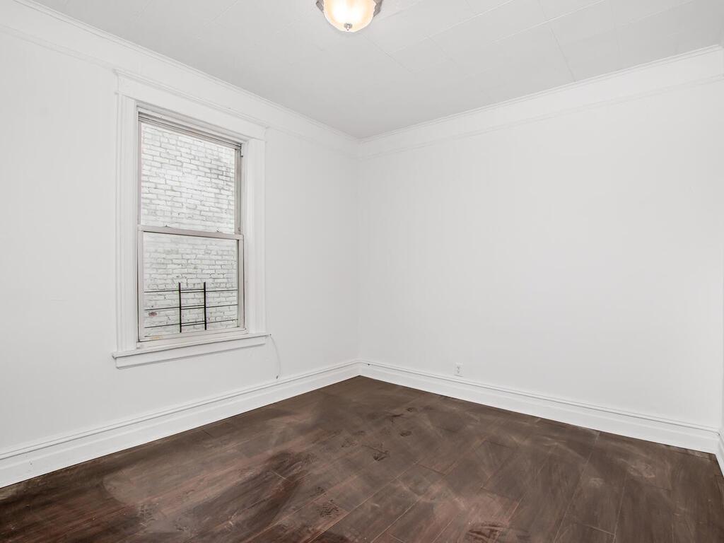 3357 Perry Avenue Bronx, NY 10467 - Photo 4 of 31 Unfurnished room featuring dark wood-style floors, baseboards, and ornamental molding