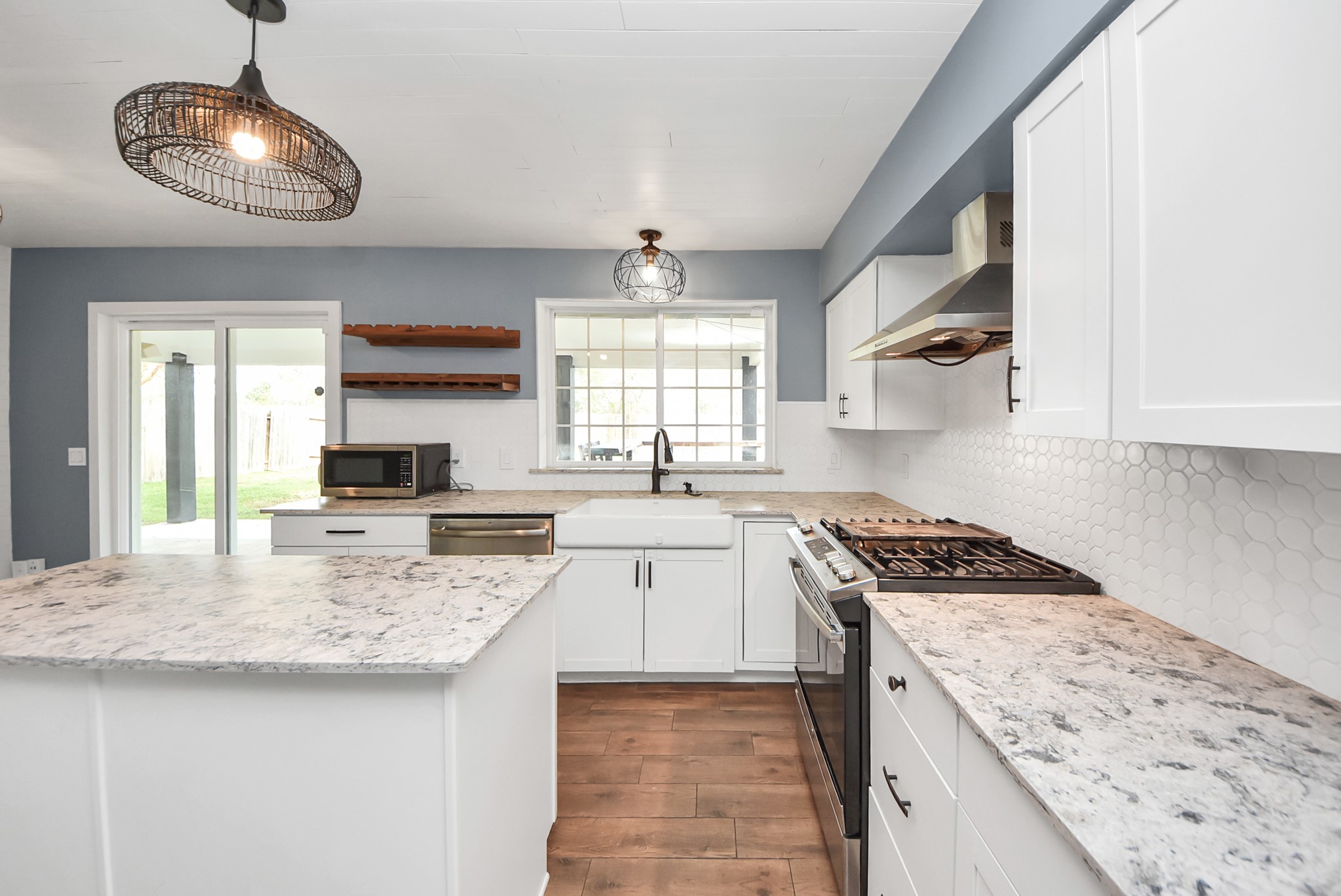 12614 Mill Ridge Drive Cypress, TX 77429 - Photo 15 of 44 a kitchen with stainless steel appliances granite countertop stove a sink dishwasher and a microwave oven with white cabinets