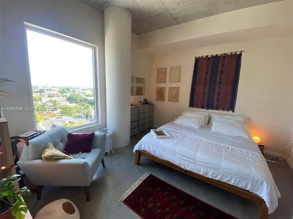 a living room with furniture and a floor to ceiling window