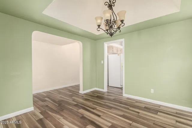 a view of a bedroom with wooden floor and chandelier