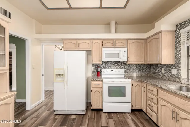 a kitchen with white cabinets and white appliances