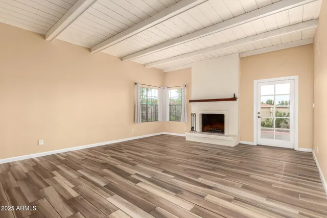 a view of empty room with wooden floor and fireplace