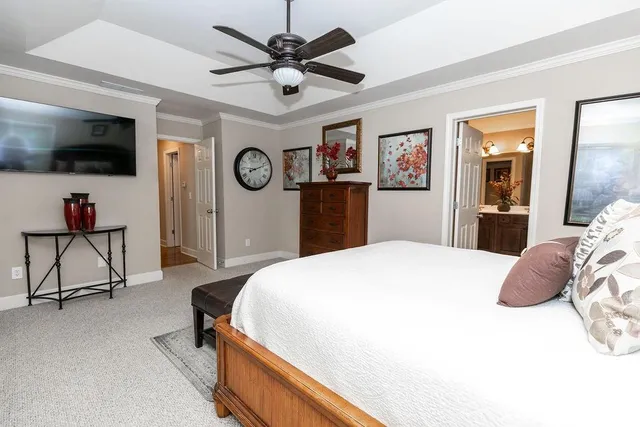 a bedroom with a bed a flat screen tv and dresser