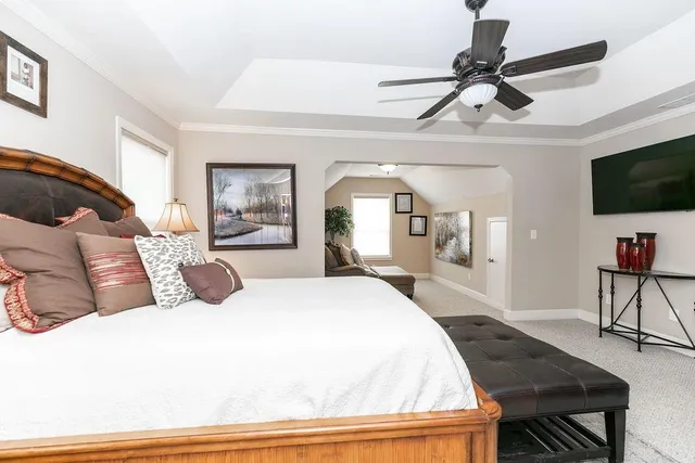 a living room with a bed furniture and a flat screen tv