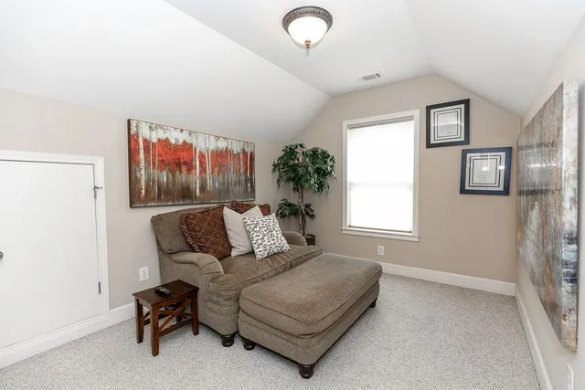 a bed room with a bed and a painting on the wall