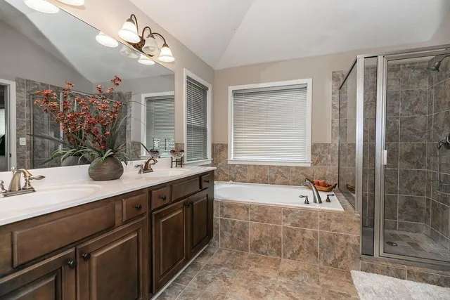 a bathroom with a tub sink and mirror