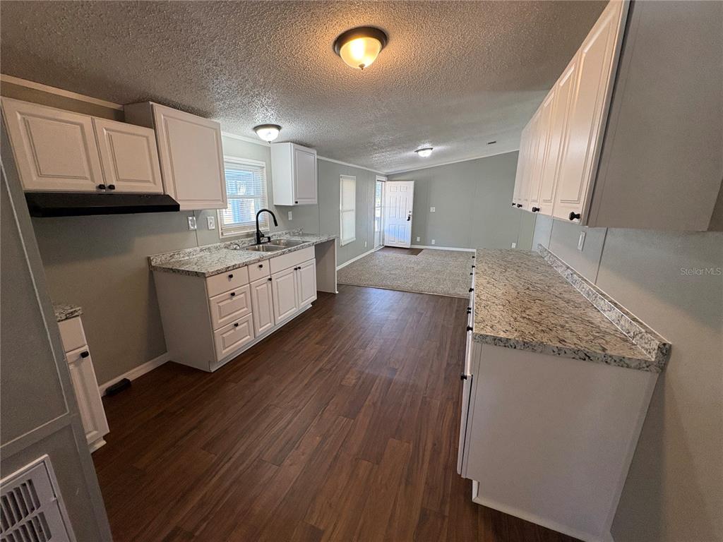 4680 Turner Road Mulberry, FL 33860 - Photo 10 of 26 a large kitchen with granite countertop a white stove top oven and white cabinets