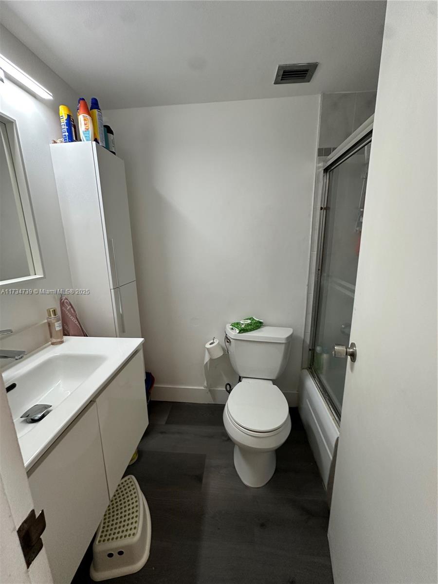 7441 Wayne Avenue, Unit 6B Miami Beach, FL 33141 - Photo 14 of 33 a white toilet sitting next to a bathroom sink and a mirror