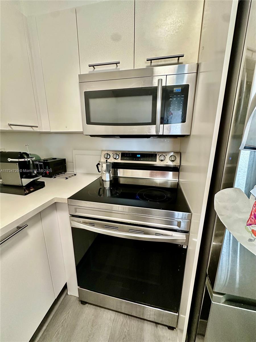 7441 Wayne Avenue, Unit 6B Miami Beach, FL 33141 - Photo 16 of 33 a kitchen with a stove and a microwave