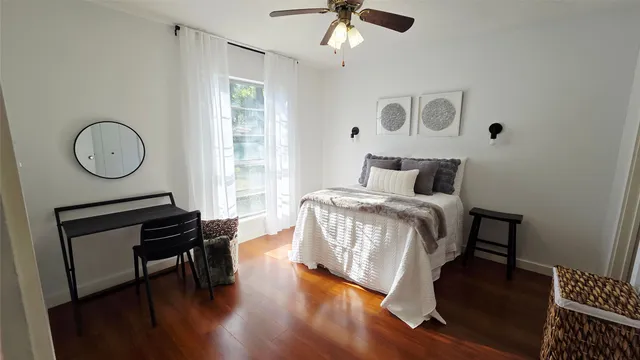 a bedroom with bed and wooden floor