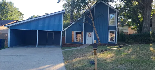 a view of house with backyard and trees