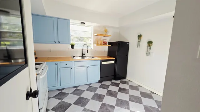 a kitchen with a checkered floor and white cabinets